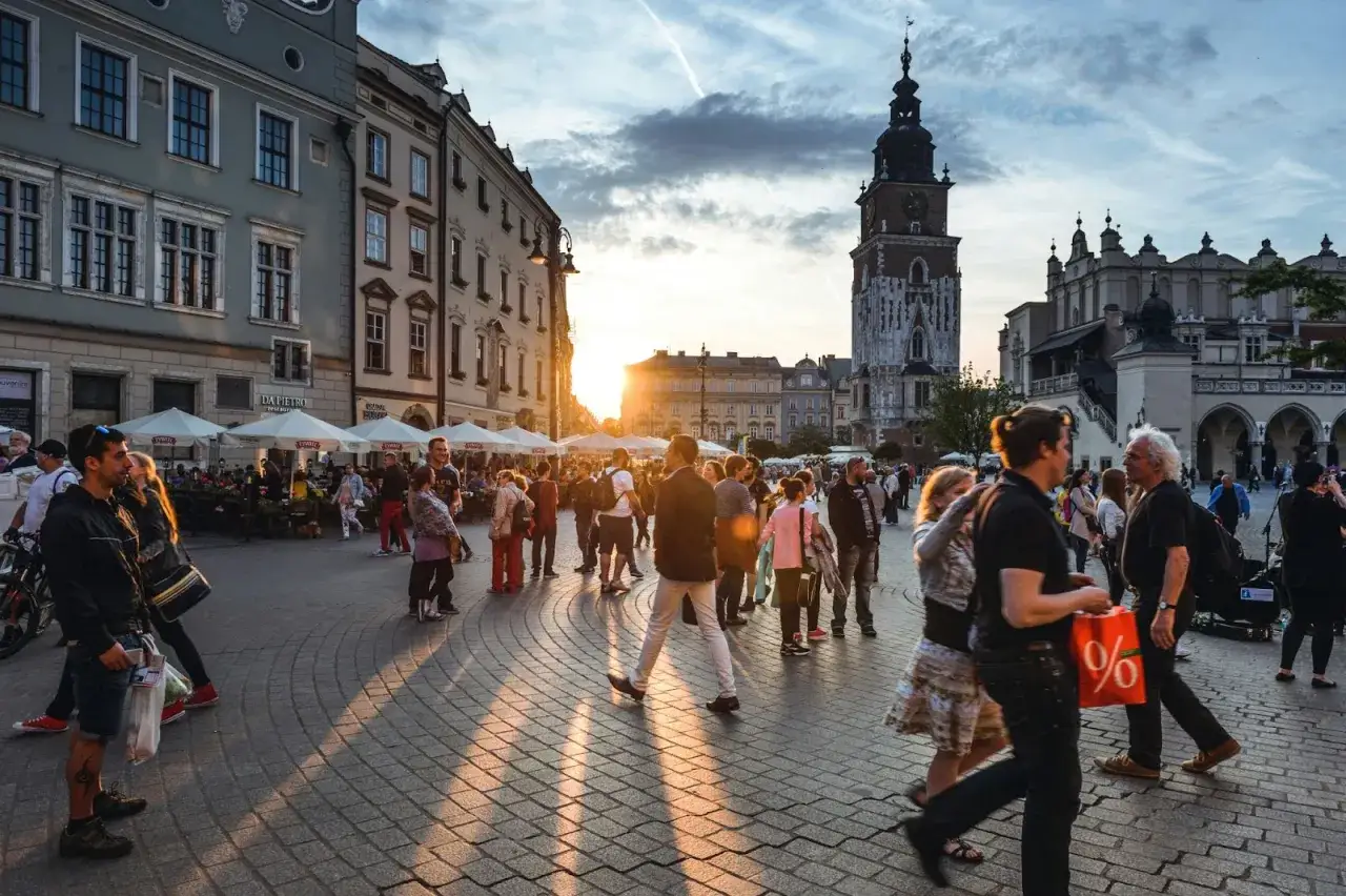 Tłum ludzi na Rynku Gł&oacute;wnym w Krakowie, zach&oacute;d słońca. Czy jest krakow safe? Tak, wygląda na to, że tak.