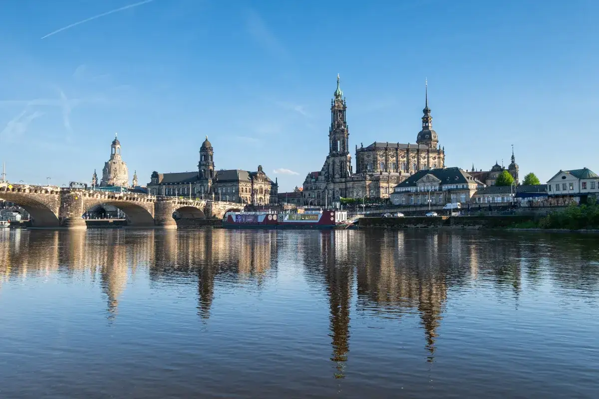 Drezno co zobaczyć: malowniczy widok na rzekę Łabę z mostem i zabytkową architekturą, w tym kościołem Frauenkirche.