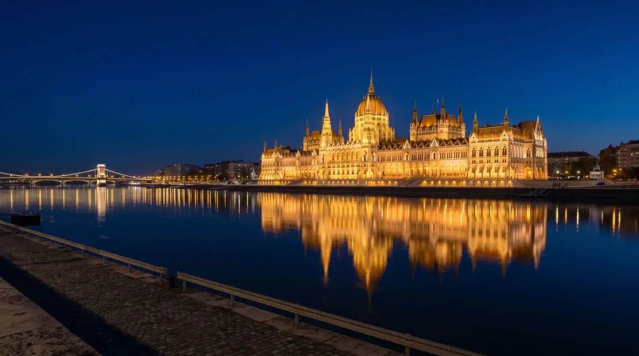 Budynek Parlamentu w Budapeszcie nocą, odbijający się w Dunaju. Węgry ciekawostki: to jeden z największych budynków parlamentu na świecie.