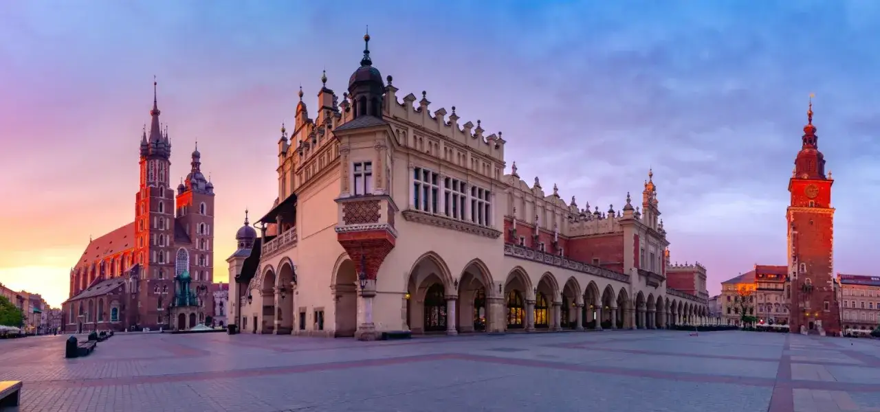 Kraków opis miasta: Sukiennice i Kościół Mariacki na Rynku Głównym o wschodzie słońca.