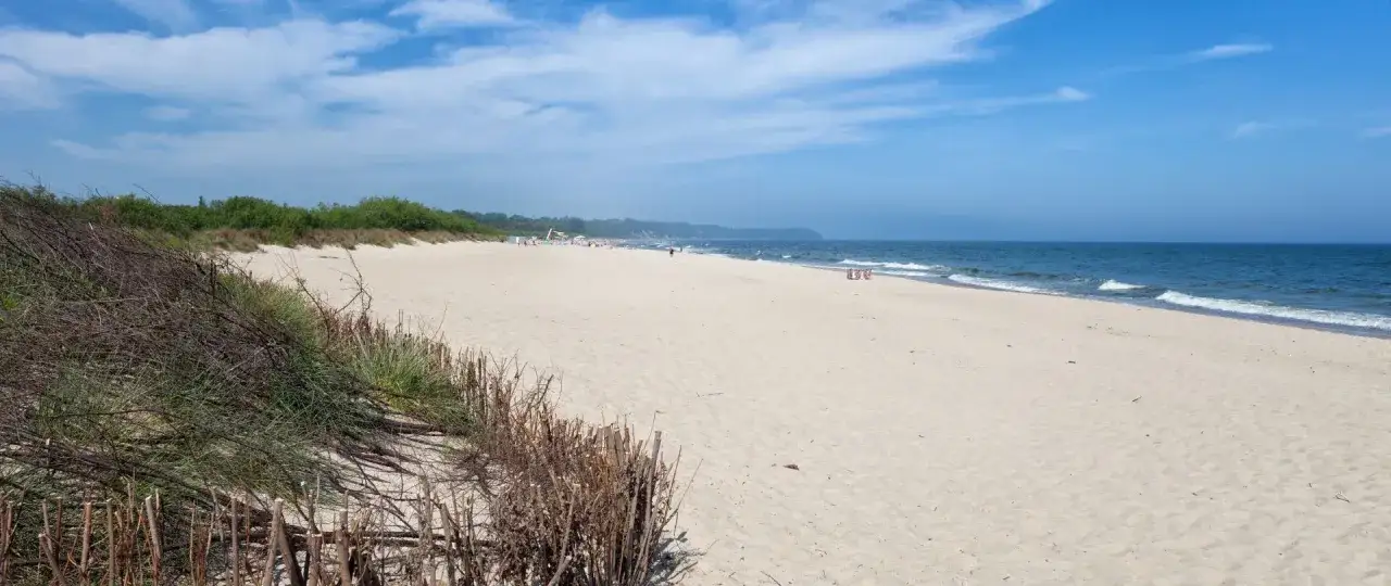 Plaża we Władysławowie, idealne miejsce na wypoczynek. W tle widać zielone wydmy i morze. Atrakcje Władysławowo i okolice czekają!