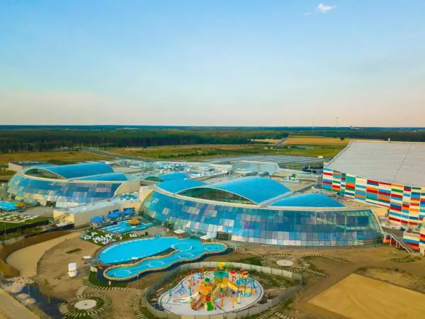 Widok z lotu ptaka na największy aqua park w Europie z błękitnymi dachami i kolorowym budynkiem.