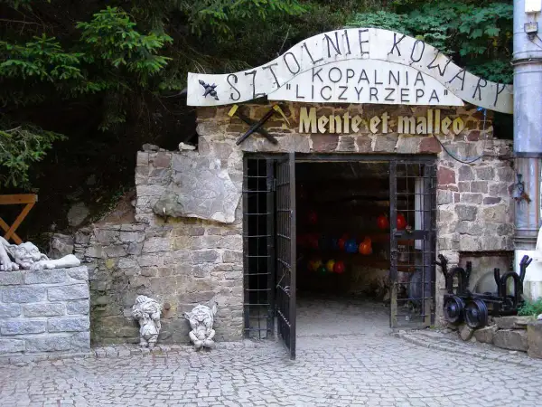 Kowary atrakcje: wejście do Sztolni Liczyrzepa, kamienne krasnale i kamienne rzeźby.