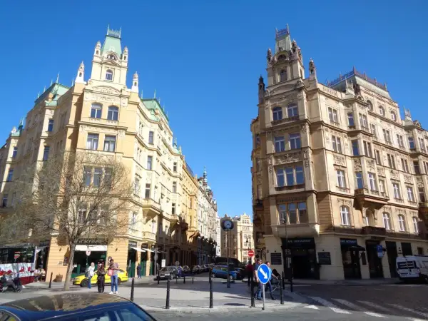 Architektura w dzielnicy żydowskiej Pragi, z secesyjnymi kamienicami i błękitnym niebem.
