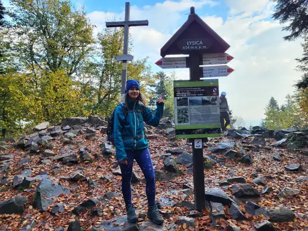 Uśmiechnięta turystka na szczycie Łysica, 614 m n.p.m. Jesienne liście i kamienie tworzą malowniczy krajobraz.