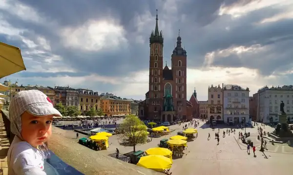 Mały chłopiec na Rynku Głównym w Krakowie, gdzie znajdziesz wiele darmowych atrakcji dla dzieci.