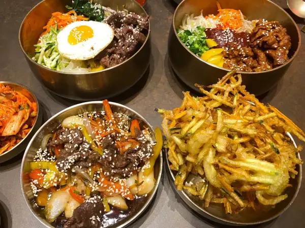 Pyszne dania kuchni koreańskiej w nooks Poznań: bibimbap, bulgogi i chrupiące warzywa w tempurze.
