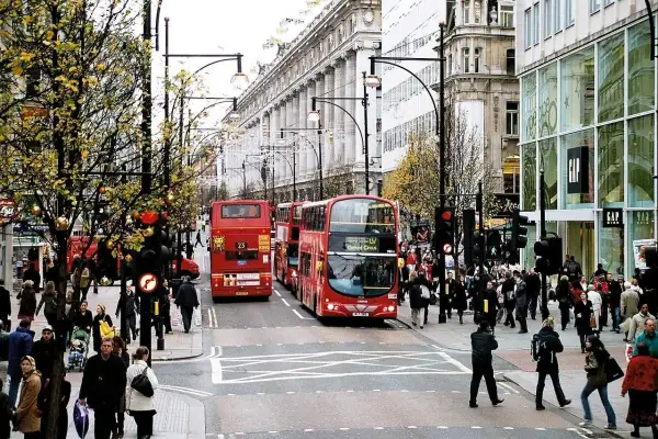 Tłum ludzi i czerwone piętrowe autobusy na najsłynniejszej ulicy w Londynie, Oxford Street.