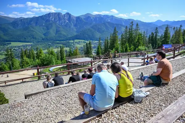Widok na Tatry z widowni, gdzie ludzie odpoczywają, ciesząc się atrakcjami Poronina.