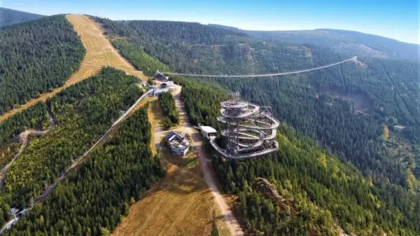 Widok na Sky Walk i wiszący most w Czechach, otoczony gęstym lasem i górskimi zboczami.